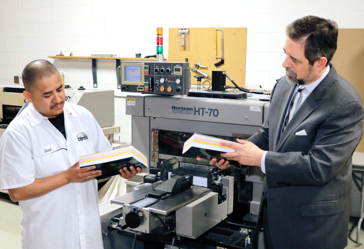 Saul and Steve inspect the final trim on a rush book at Copresco
